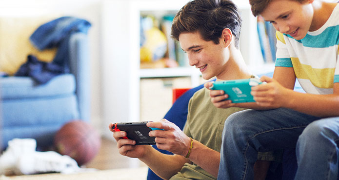 Garçons jouant à la Nintendo Switch dans un salon